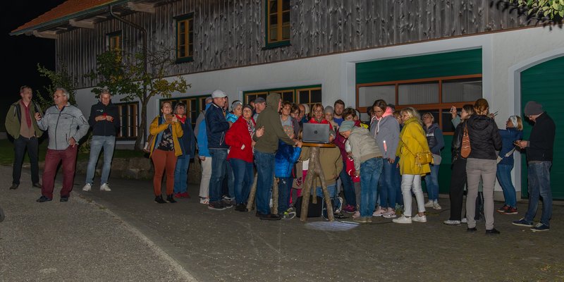 Foto: Menschengruppe vor einem Gebäude bei einer nächtlichen Wanderung
